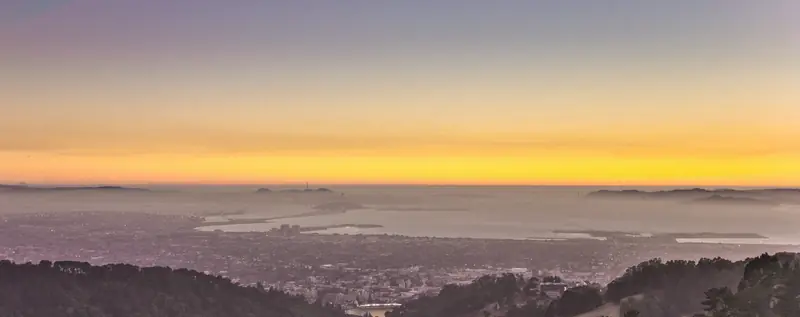 Photo of an orange sunset over fog, Berkeley and San Francisco Bay